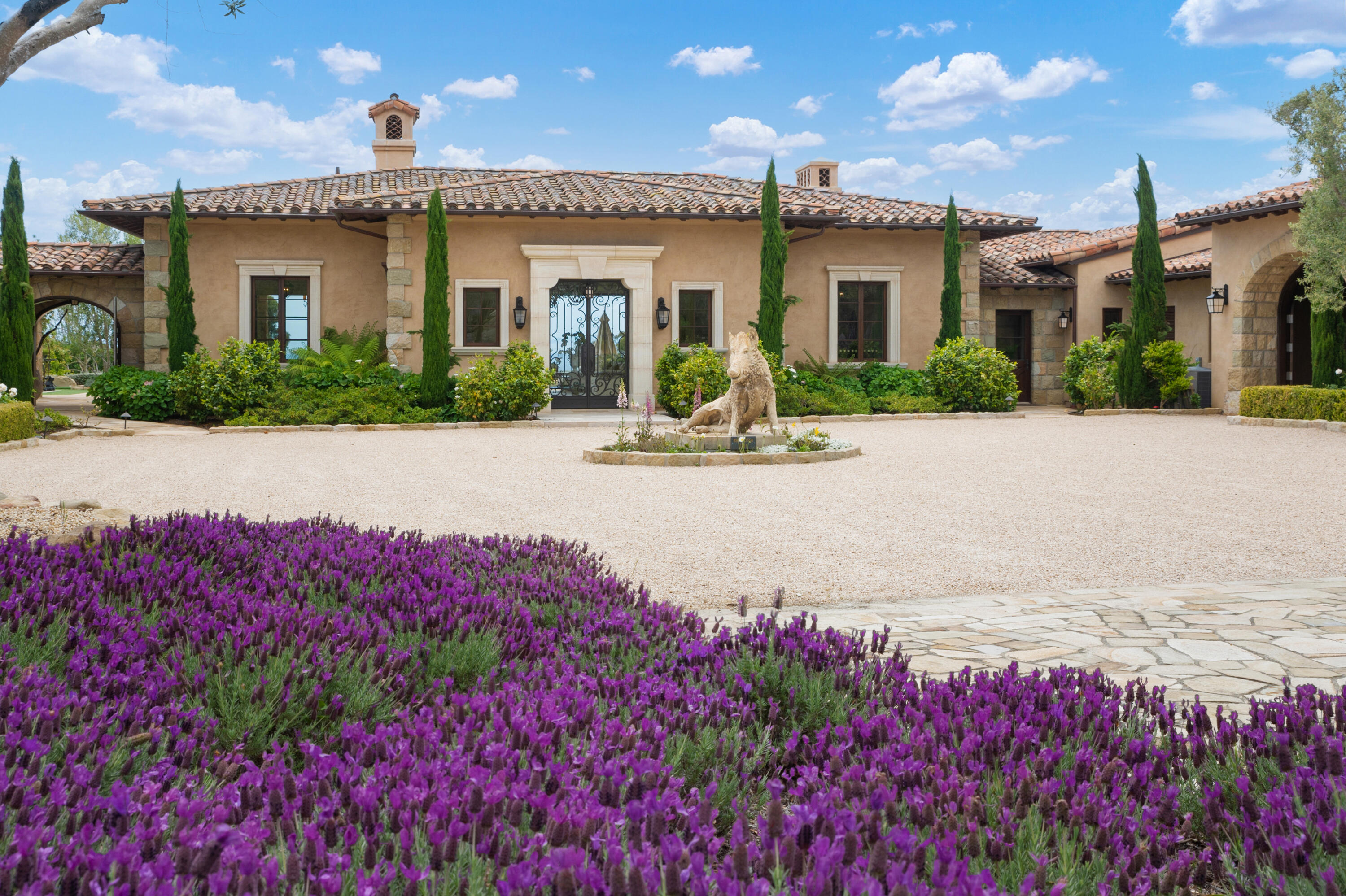 130 Montecito Ranch Lane Summerland, CA 93067 - Photo 2 of 33 a view of a white house with a flower garden in front of it
