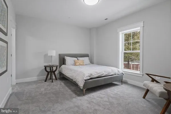 a bed sitting in a bedroom next to a window