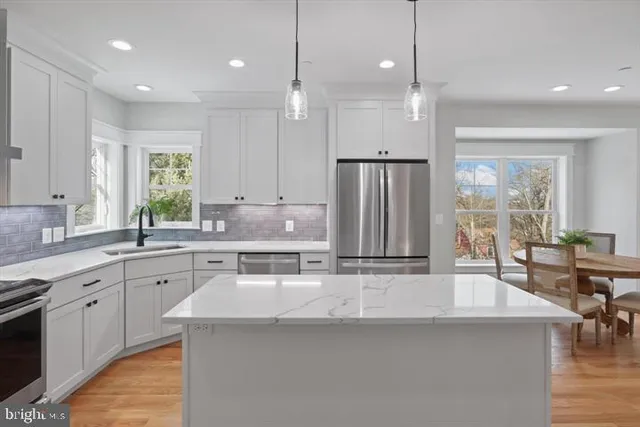 a kitchen with stainless steel appliances granite countertop a sink a stove and a refrigerator