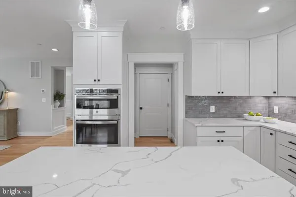 a kitchen with stainless steel appliances a stove refrigerator and cabinets