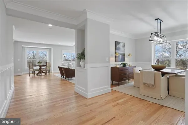 a living room with couches and kitchen view with wooden floor