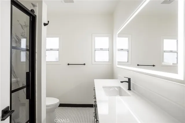 a bathroom with a sink a toilet and shower