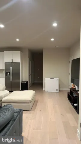 a living room with stainless steel appliances furniture and a flat screen tv