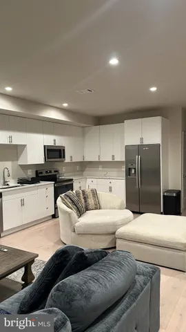 a kitchen with a refrigerator and white cabinets