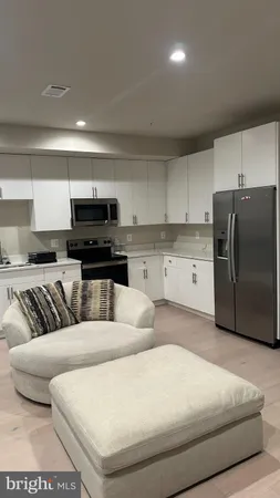 a living room with furniture and a refrigerator