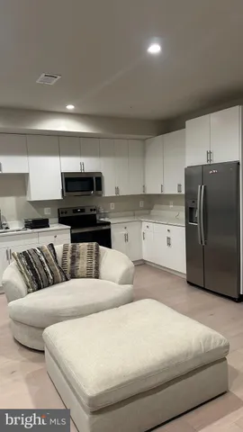 a living room with furniture and a refrigerator