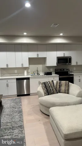 a living room with stainless steel appliances kitchen island granite countertop a sink and a stove