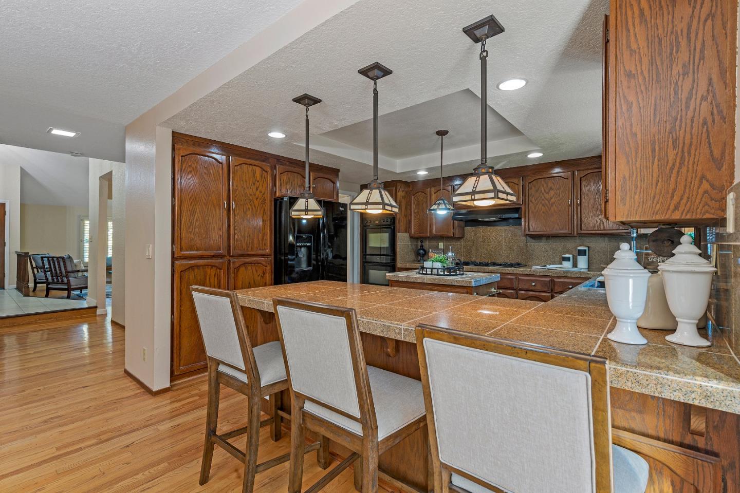 7054 Morecambe Drive San Jose, CA 95120 - Photo 41 of 50 a kitchen with stainless steel appliances granite countertop a sink a refrigerator a stove and white cabinets with wooden floor
