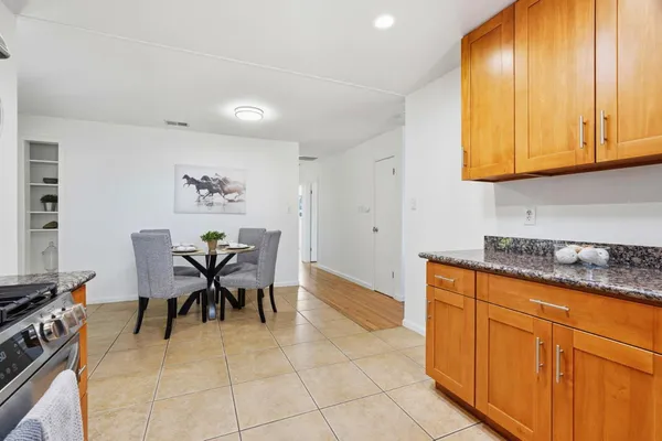 a dining room with granite countertop furniture and a kitchen area