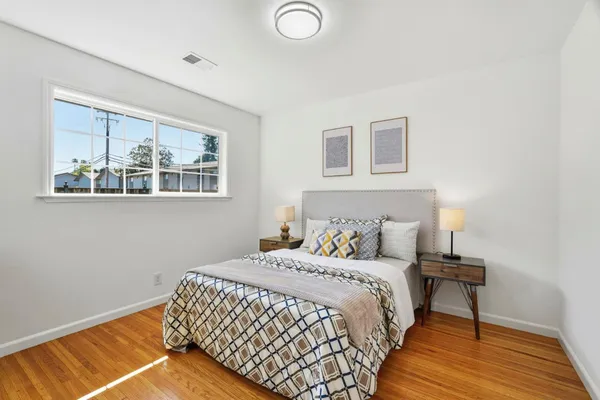 a bedroom with a bed and wooden floor