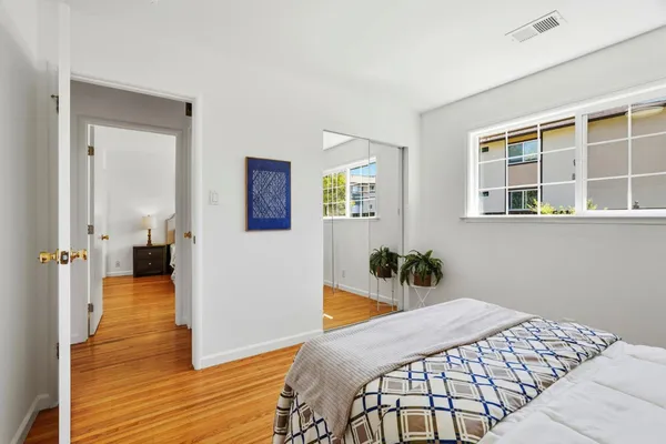 a bedroom with a bed and wooden floor