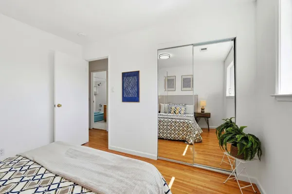 a bedroom with a bed and a potted plant