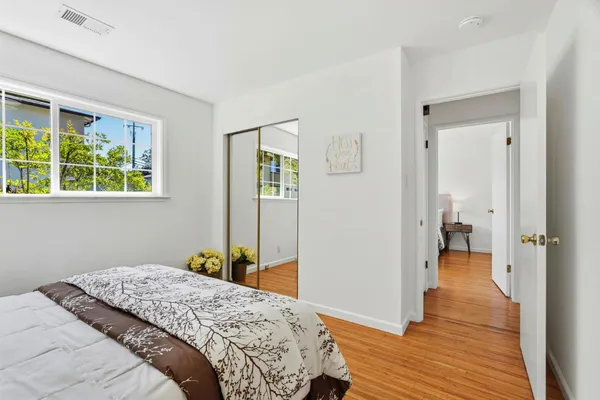 a bedroom with a bed and wooden floor