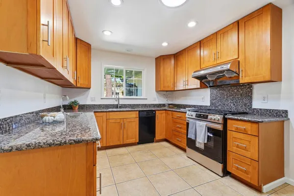 a kitchen with stainless steel appliances granite countertop sink stove and granite counter top