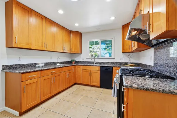 a kitchen with stainless steel appliances granite countertop wooden cabinets a sink and dishwasher