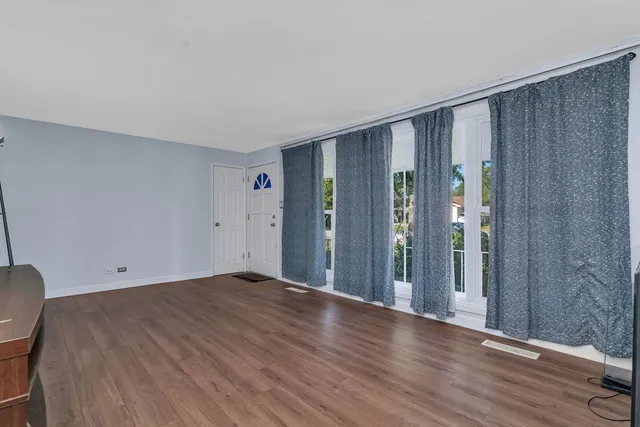 a view of an empty room with wooden floor