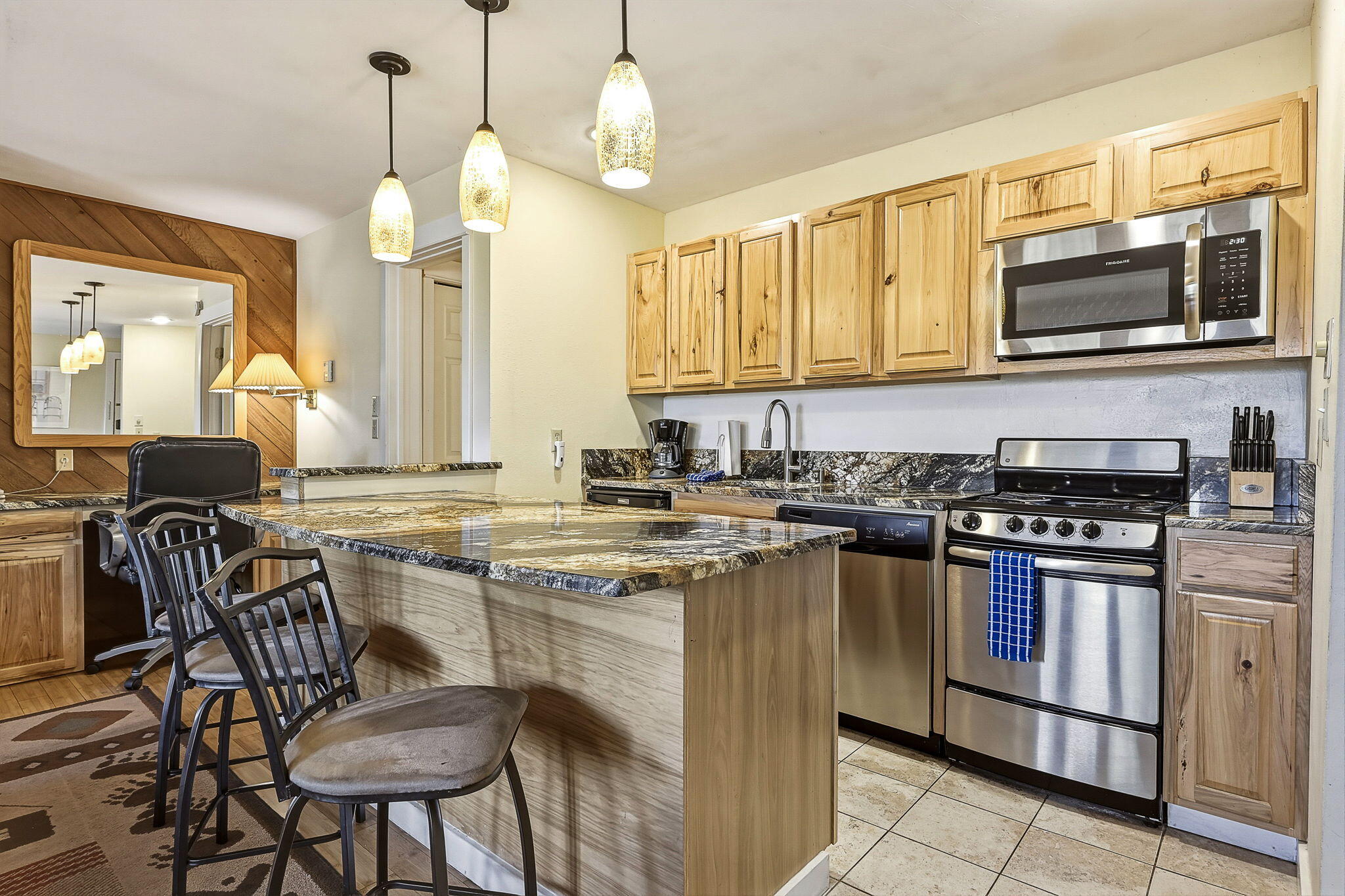 18575 Southwest Century Drive, Unit 232 Bend, OR 97702 - Photo 6 of 37 a kitchen with stainless steel appliances granite countertop a stove top oven a sink dishwasher a dining table and chairs with wooden floor