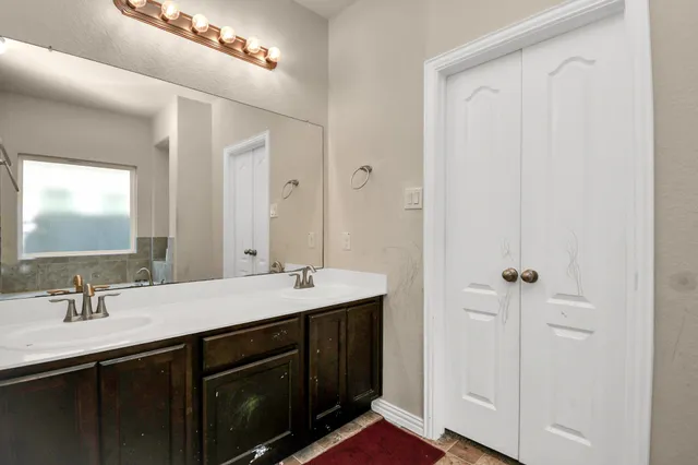 a bathroom with a double vanity sink and mirror