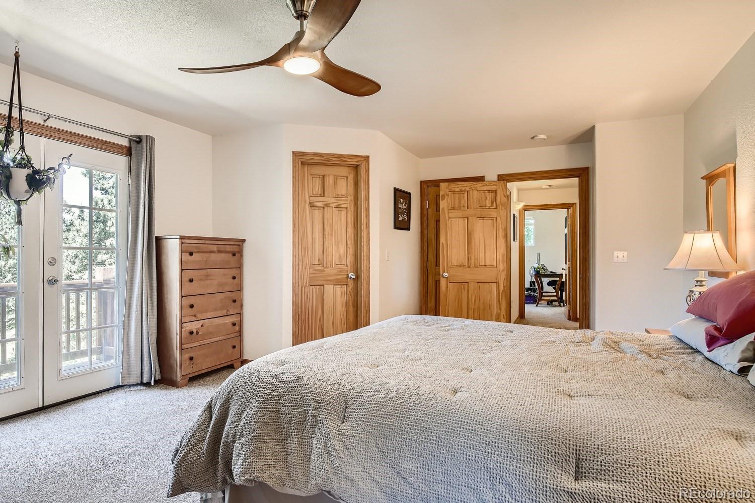 731 Hitchrack Road Bailey, CO 80421 - Photo 12 of 22 a bedroom with a large bed and a chandelier