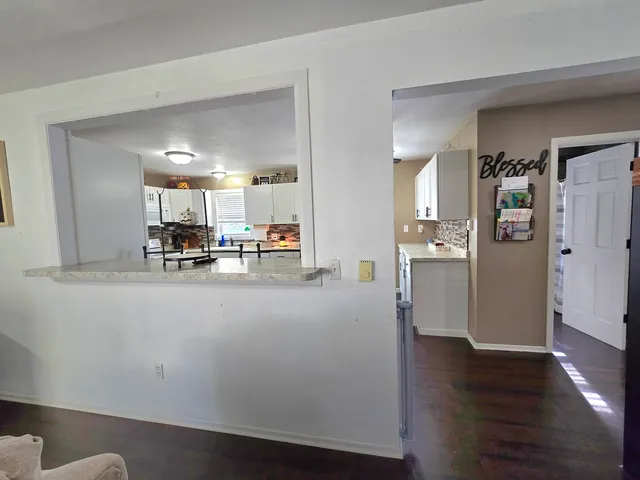 a view of kitchen with refrigerator and wooden floor