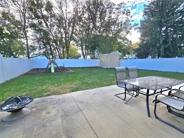 a view of a backyard with table and chairs and a slide