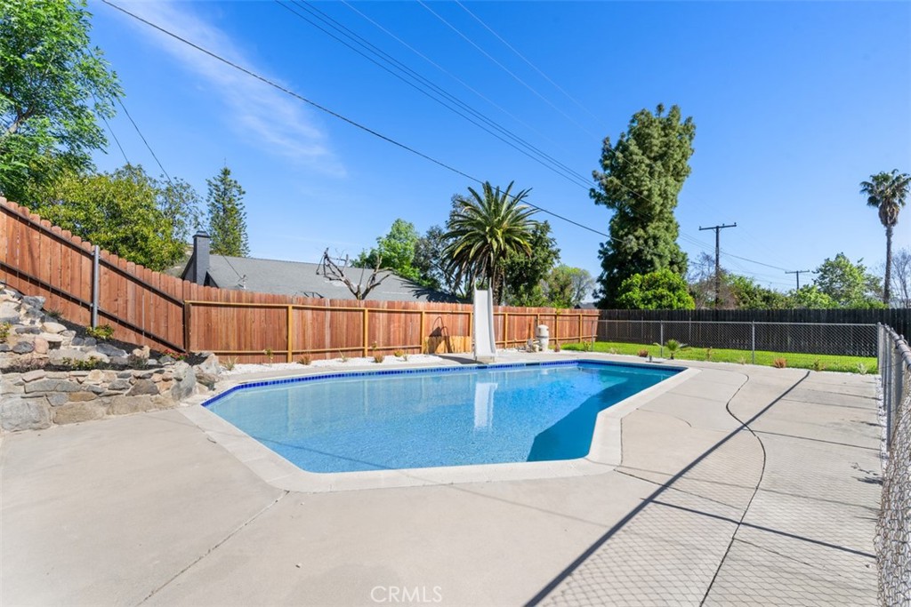 5417 Peacock Lane Riverside, CA 92505 - Photo 35 of 44 a view of a swimming pool with a yard and palm trees