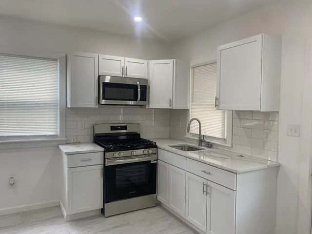 a kitchen with white cabinets and stainless steel appliances