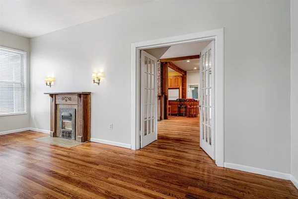 an empty room with wooden floor closet and windows