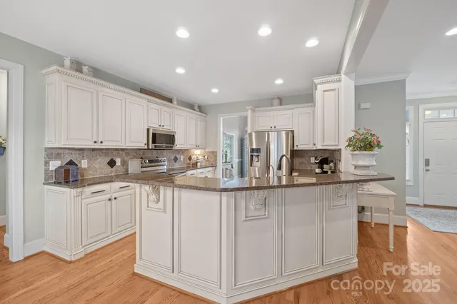 a kitchen with stainless steel appliances granite countertop a stove a sink and a microwave