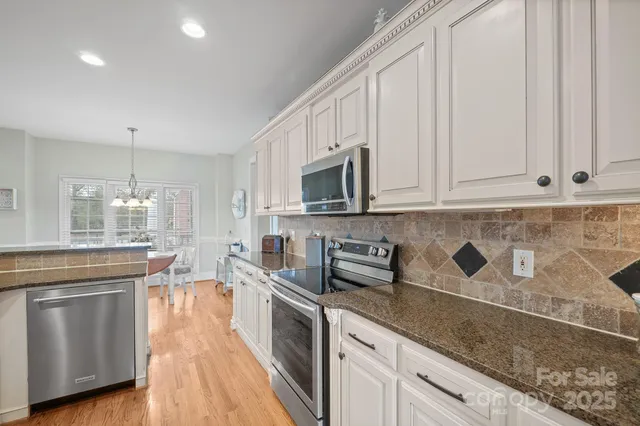 a view of a dining room with furniture a chandelier and wooden floor