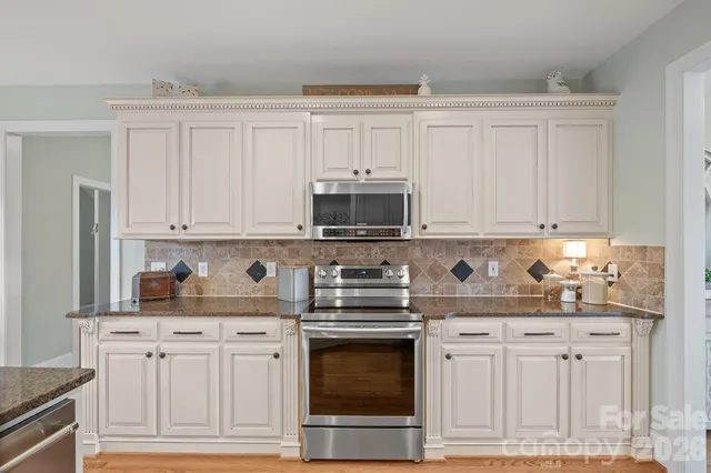 a view of a dining room with furniture a chandelier and wooden floor