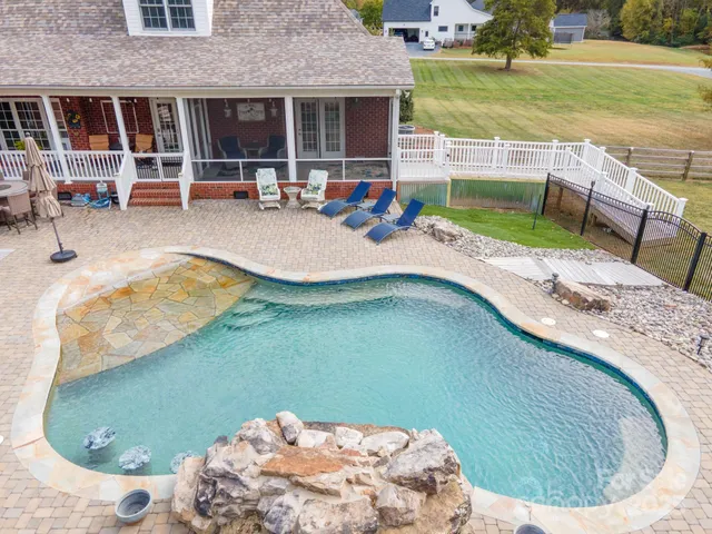a swimming pool with outdoor seating and yard