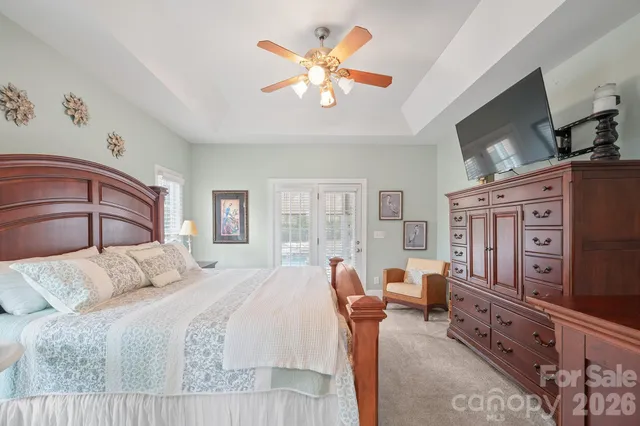 a bedroom with a large bed and a flat tv screen on dresser