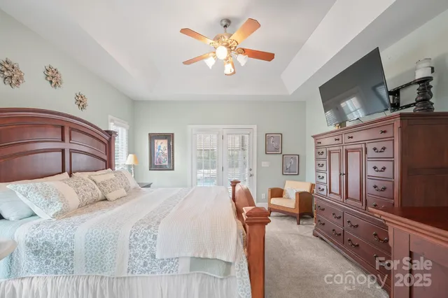 a bedroom with a large bed and a flat tv screen on dresser