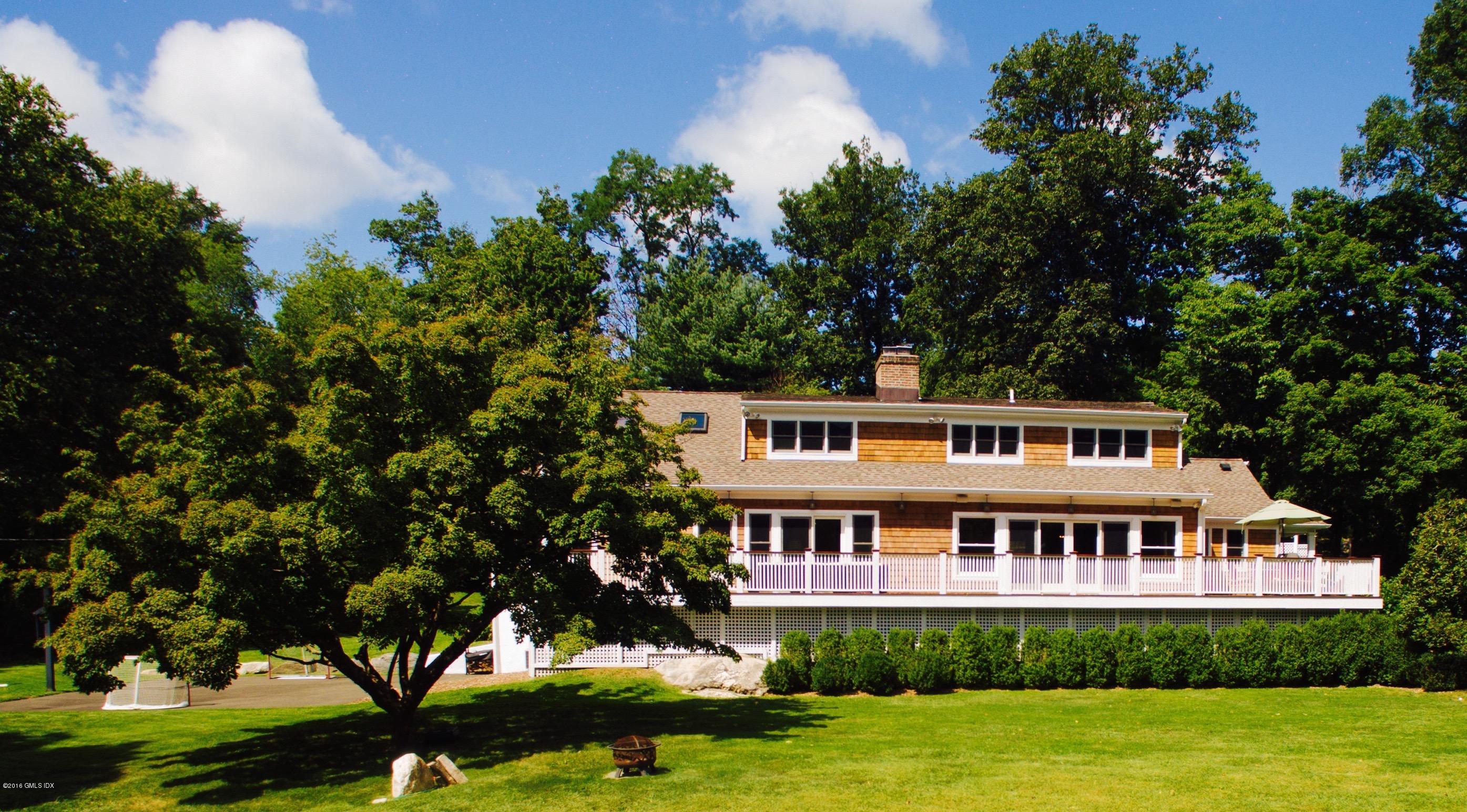 102 Hunting Ridge Road Greenwich, CT 06831 - Photo 3 of 29 a front view of a house with a garden