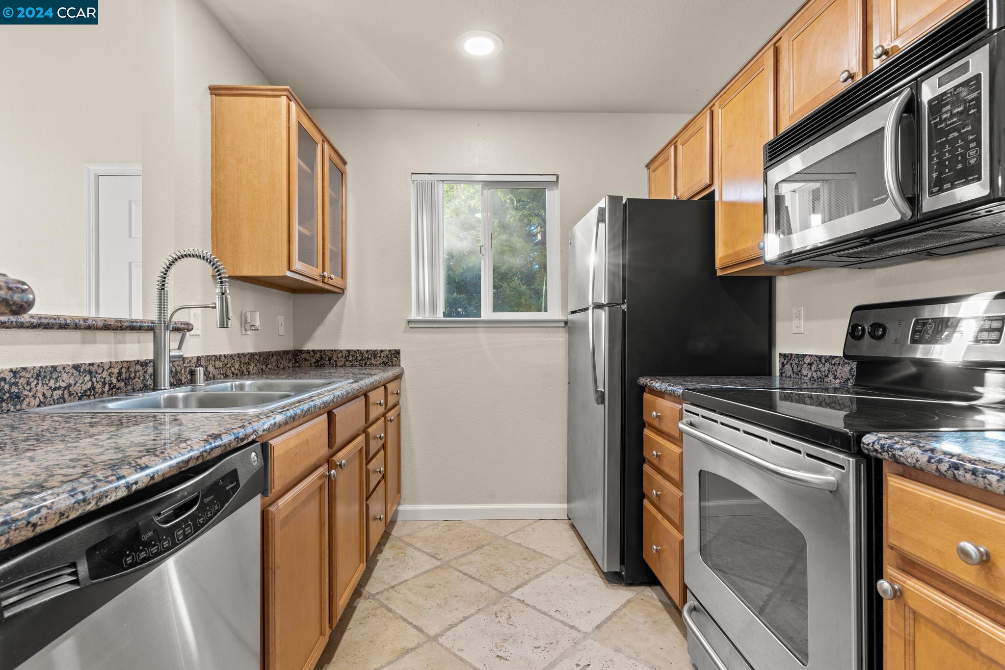 285 Reflections Drive, Unit 25 San Ramon, CA 94583 - Photo 12 of 42 a kitchen with stainless steel appliances granite countertop a sink stove and refrigerator