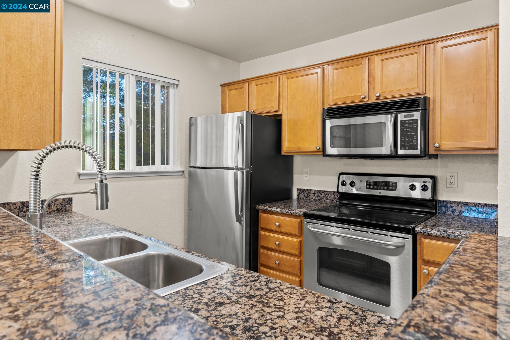 285 Reflections Drive, Unit 25 San Ramon, CA 94583 - Photo 8 of 42 a kitchen with granite countertop a sink cabinets and stainless steel appliances