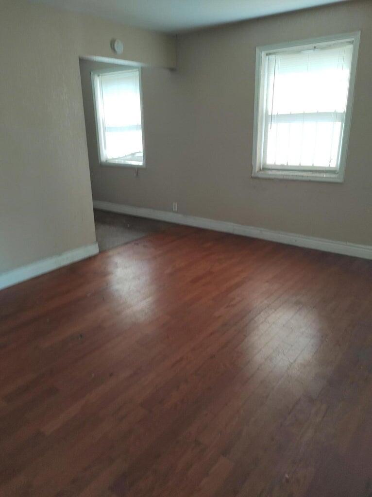 587 West 4th Street Riviera Beach, FL 33404 - Photo 5 of 10 an empty room with wooden floor and windows