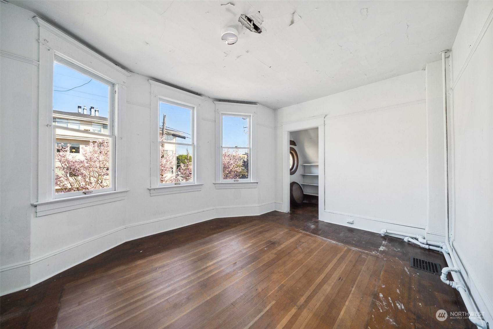 3840 Linden Avenue North Seattle, WA 98103 - Photo 18 of 40 a view of an empty room with wooden floor and a window