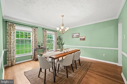 a kitchen with stainless steel appliances granite countertop a stove a sink and white cabinets with wooden floor