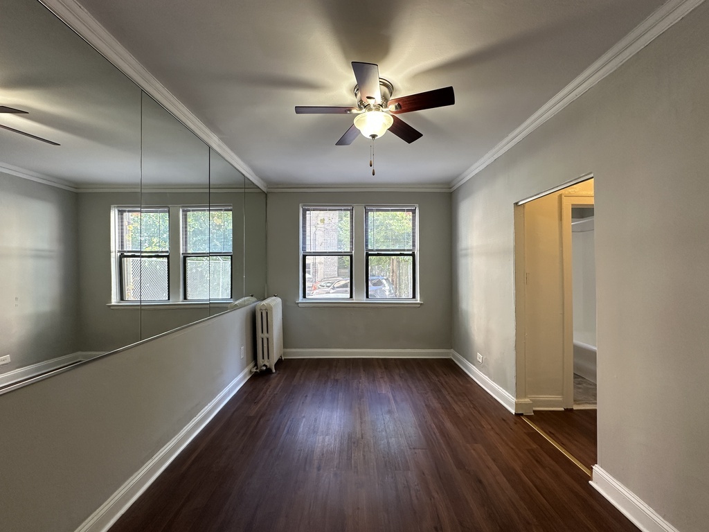 661 West Sheridan Road, Unit 208 Chicago, IL 60613 - Photo 8 of 20 a view of empty room with wooden floor and fan