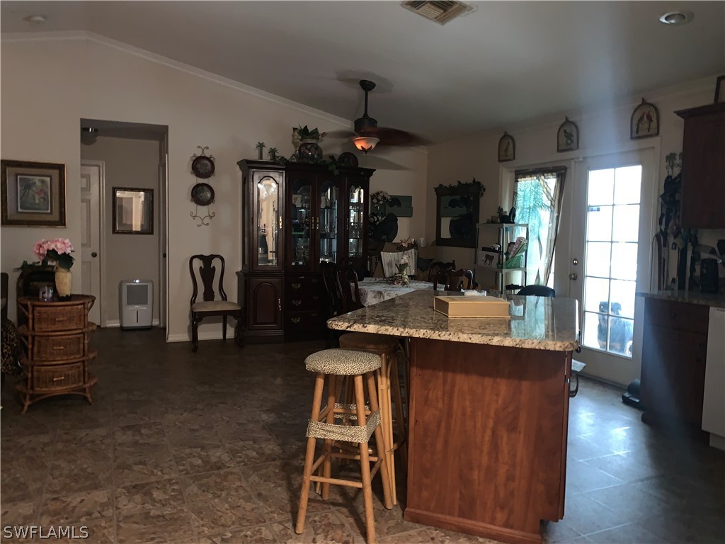 18599 Flamingo Road Fort Myers, FL 33967 - Photo 13 of 30 a view of kitchen island kitchen island dining table and wooden floor