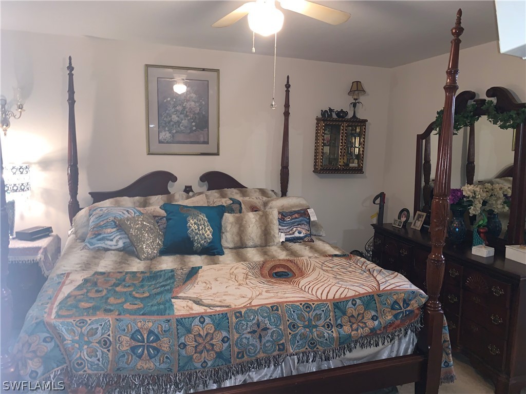 18599 Flamingo Road Fort Myers, FL 33967 - Photo 16 of 30 a bedroom with a bed and a chandelier