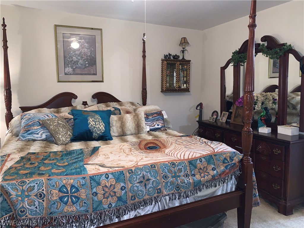18599 Flamingo Road Fort Myers, FL 33967 - Photo 18 of 30 a bedroom with a bed a painting on the wall and a dresser