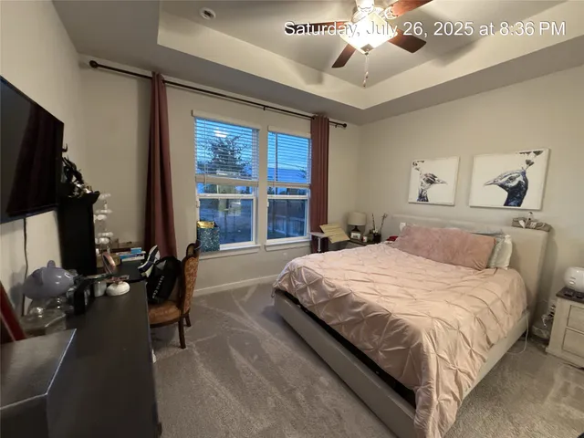 a spacious bedroom with a large bed and a chandelier