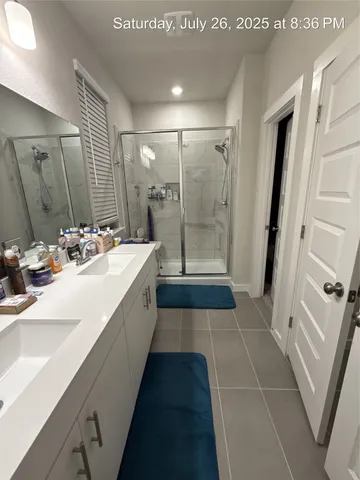 a bathroom with a double vanity sink a mirror and a shower