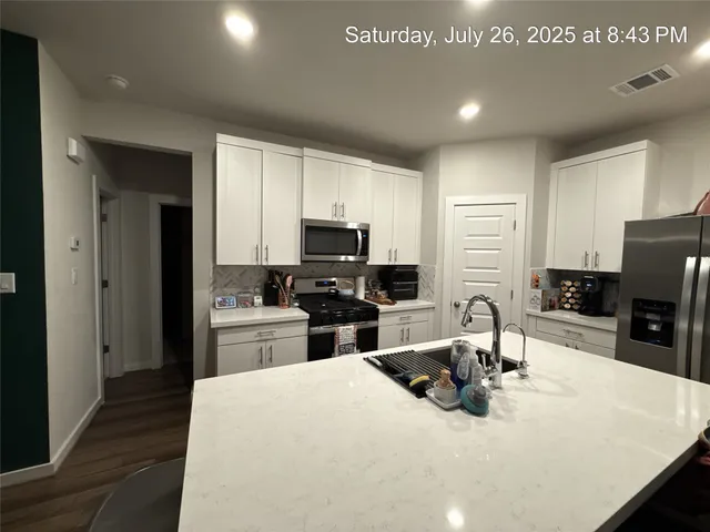 a kitchen with kitchen island a sink appliances and cabinets