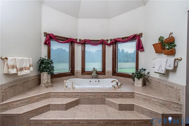 a bathroom with a tub sink and mirror
