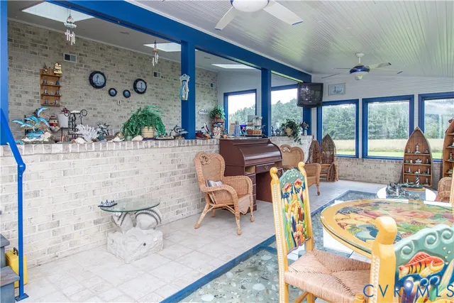 a living room with patio furniture and a floor to ceiling window