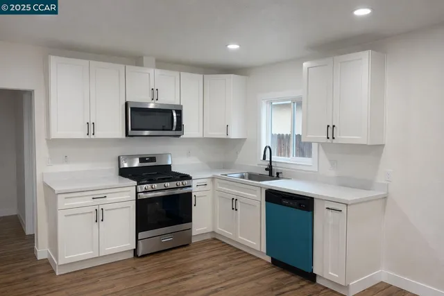 a kitchen with stainless steel appliances granite countertop a sink stove and cabinets